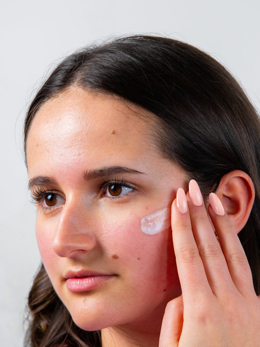 Mujer aplicando crema hidratante Guinot en el rostro