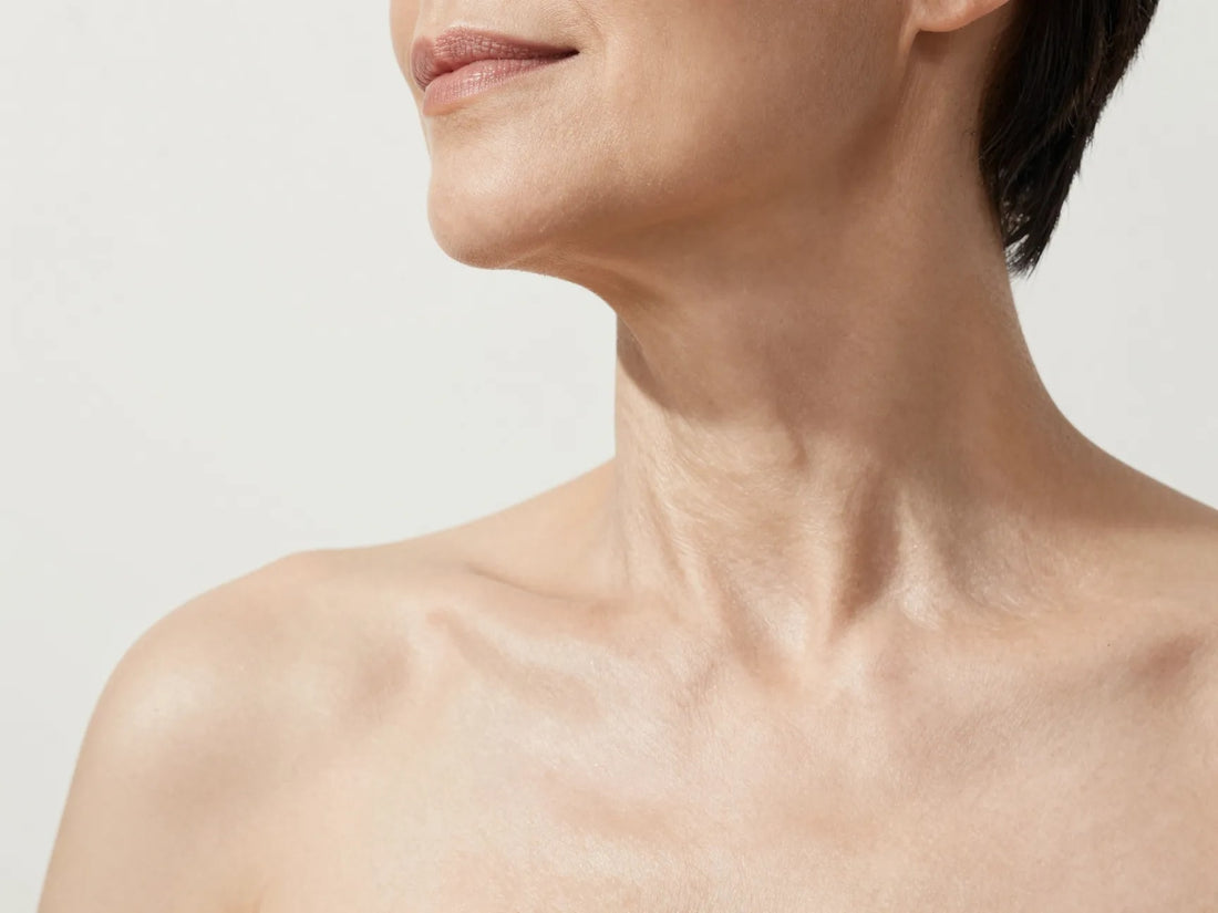 Primer plano del cuello y el escote de una mujer con piel luminosa y firme
