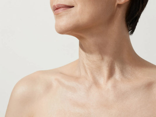 Primer plano del cuello y el escote de una mujer con piel luminosa y firme