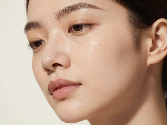 Primer plano de rostro con piel luminosa e hidratada con gotas de agua