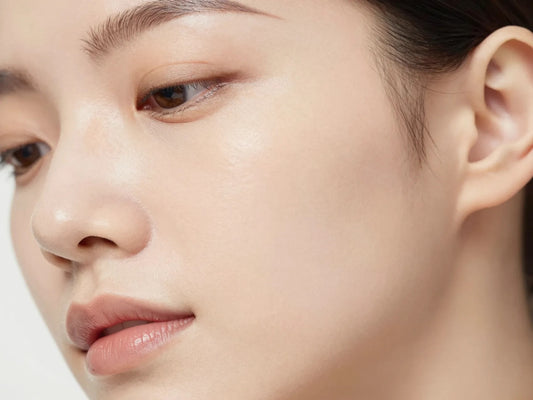 Primer plano de rostro con piel luminosa y textura fina, cuidado de poros Guinot